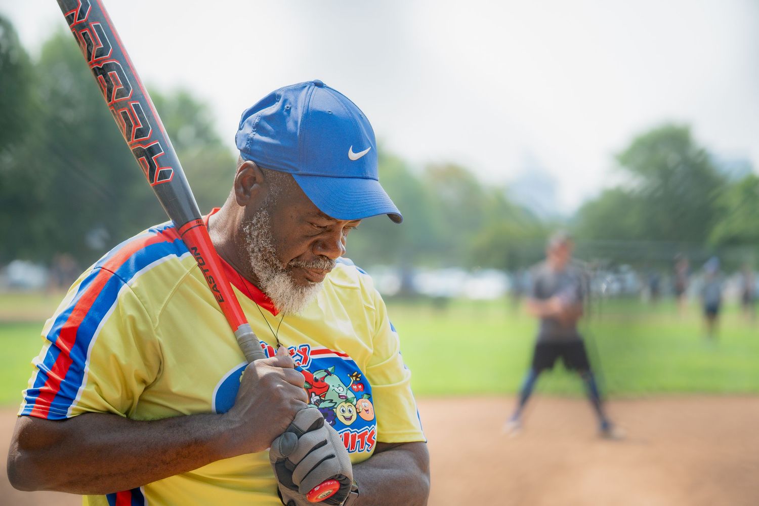 A softball athlete prepares to swing on a pitch in a park in Chicago