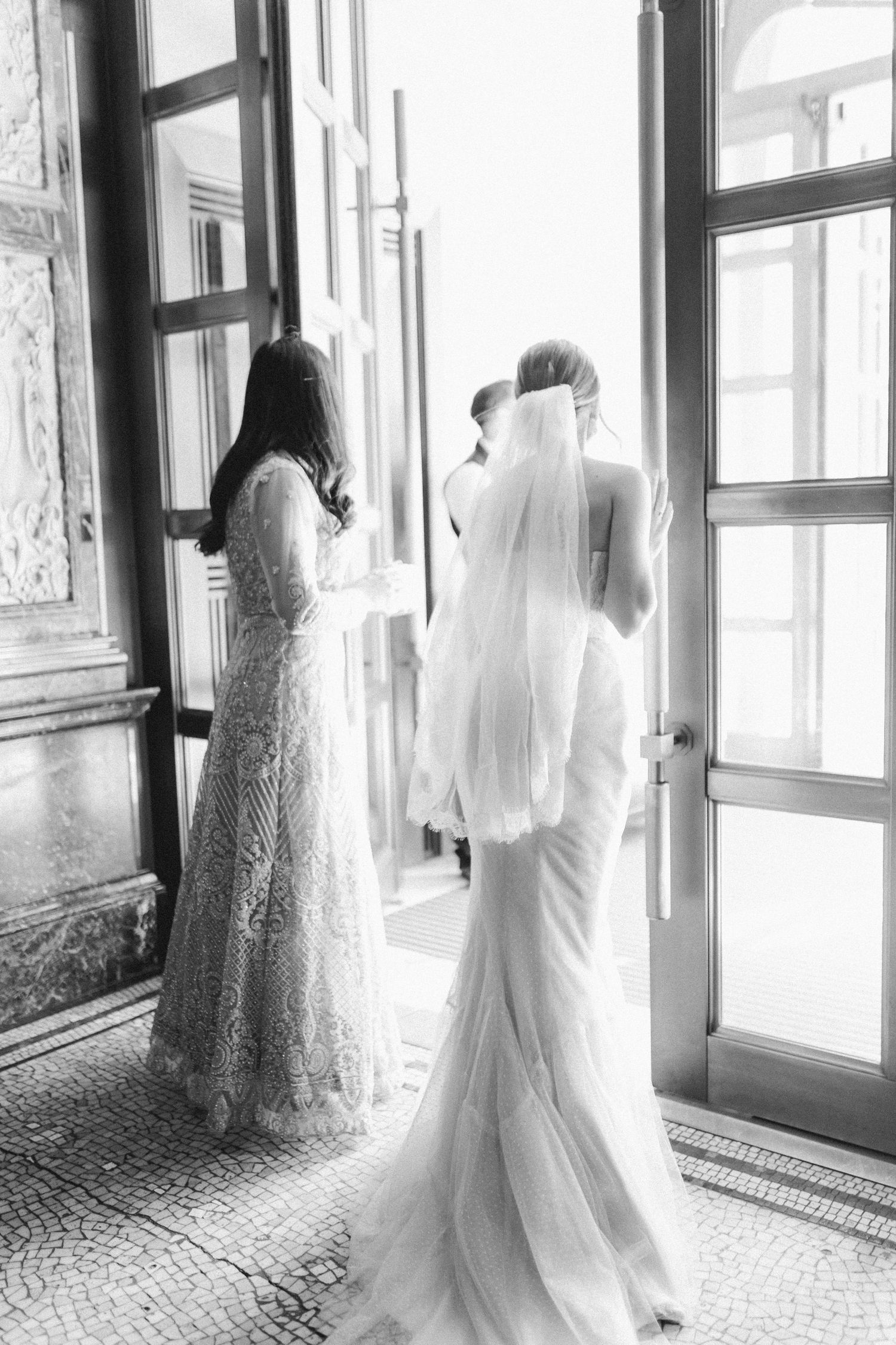 A black and white wedding photo showing elegant lace dresses in front of bright windows at The Lord Nelson, Halifax