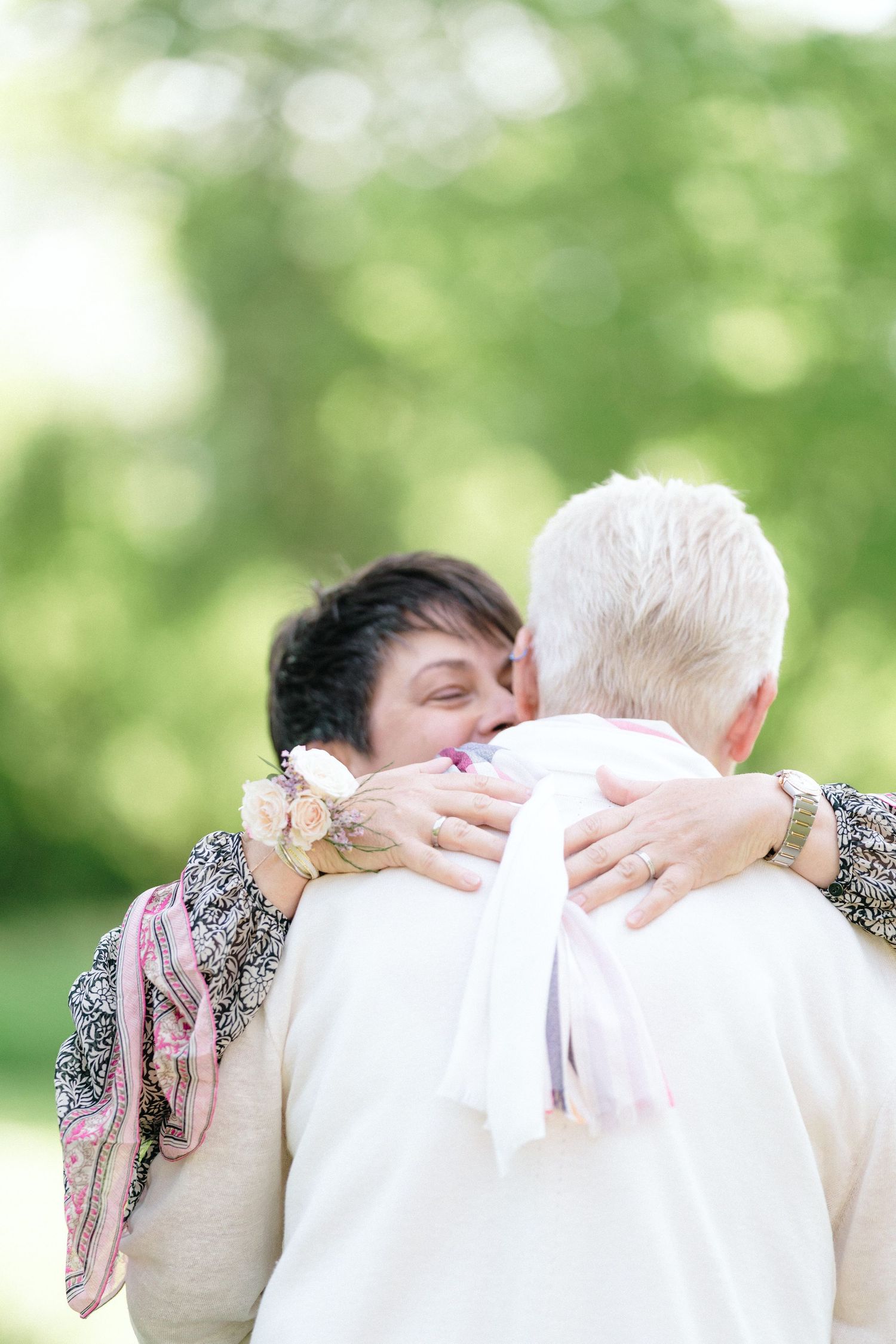 An emotional embrace by LGBTQ couple captured outdoors with soft bokeh green background near The Lord Nelson, Halifax