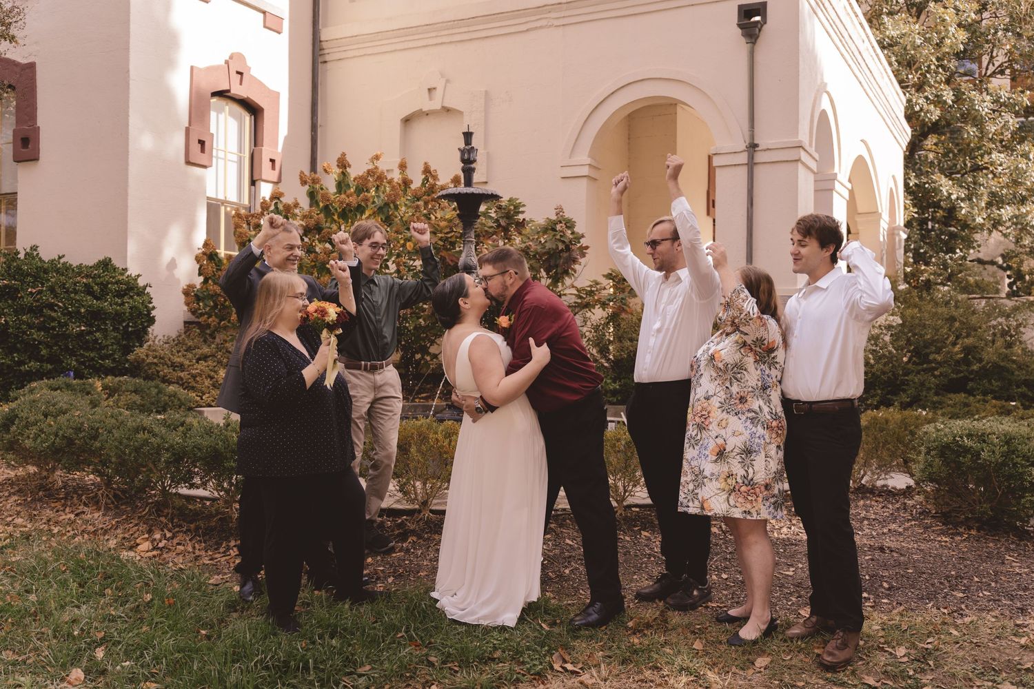 Newlyweds kissing and celebrating with family outside Cabarrus County Courthouse in Concord, NC