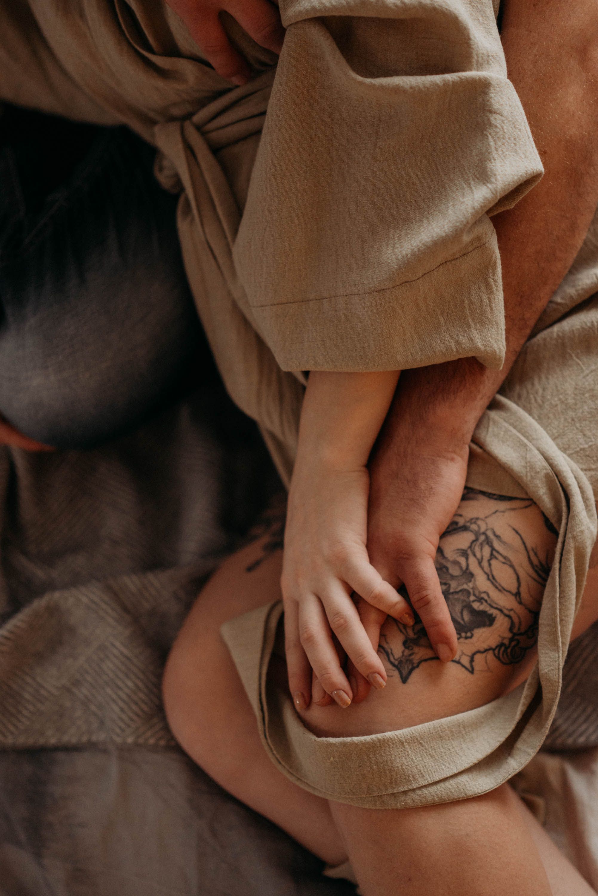 Detail shots of tattoo art on skin with neutral toned fabric creating texture and depth.