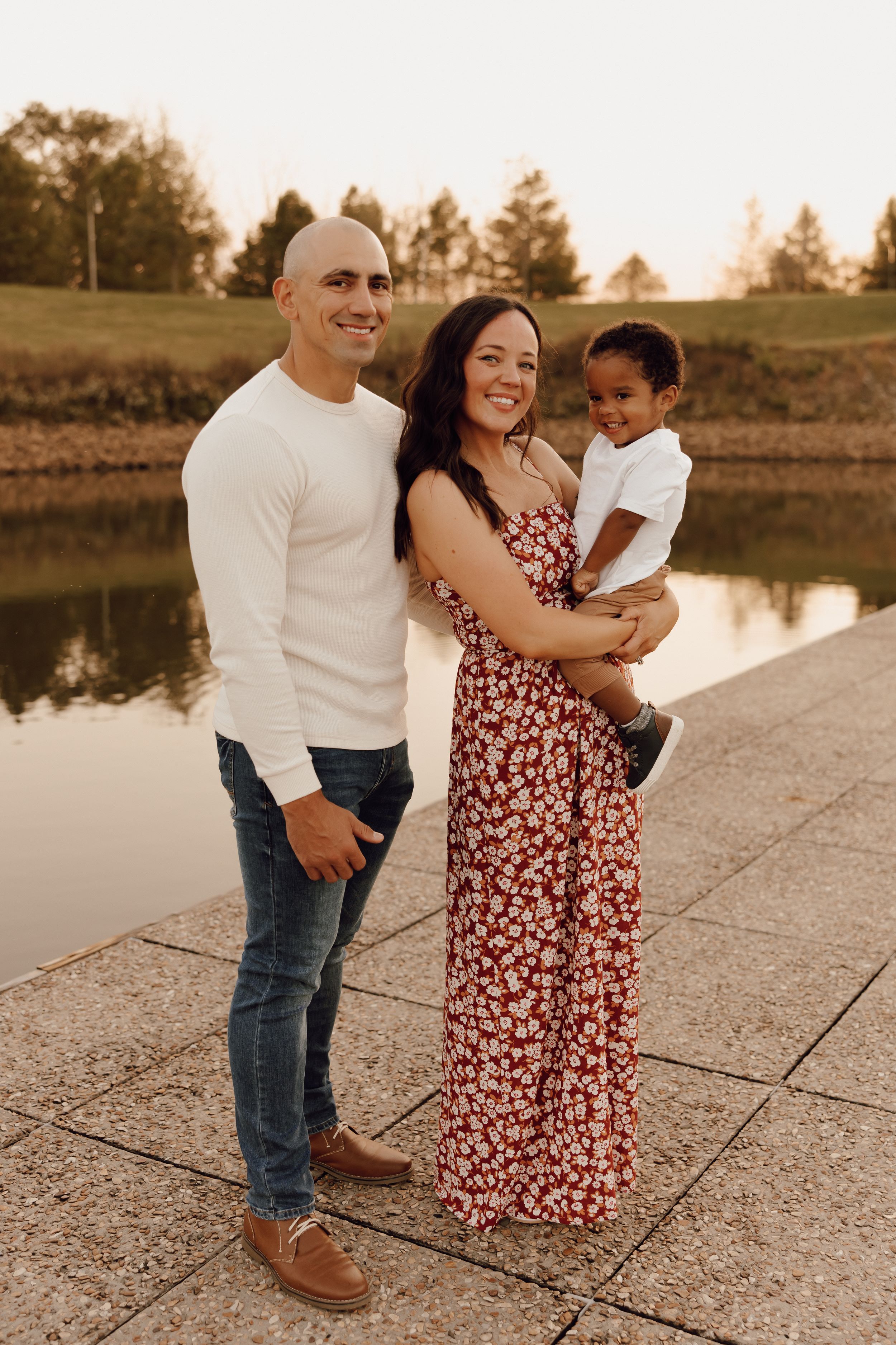 Casual family photo session with parents and children, captured in a lush park setting.