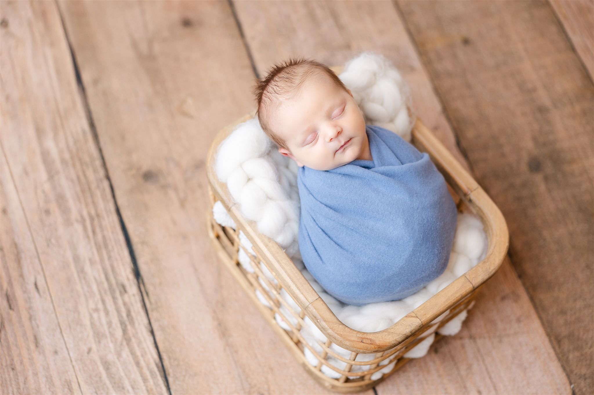 baby in blue on wood floor