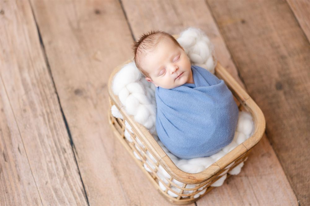 baby in blue on wood floor