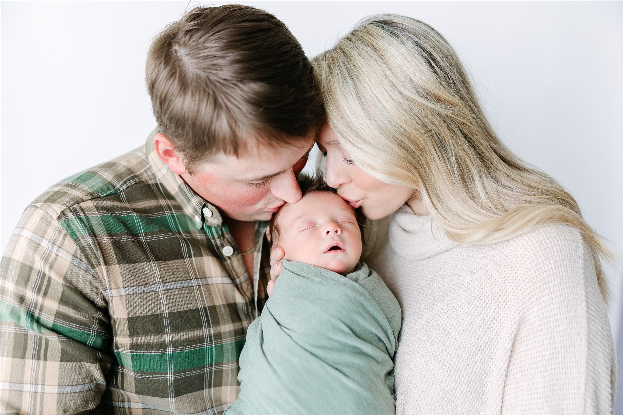 baby in green with parents