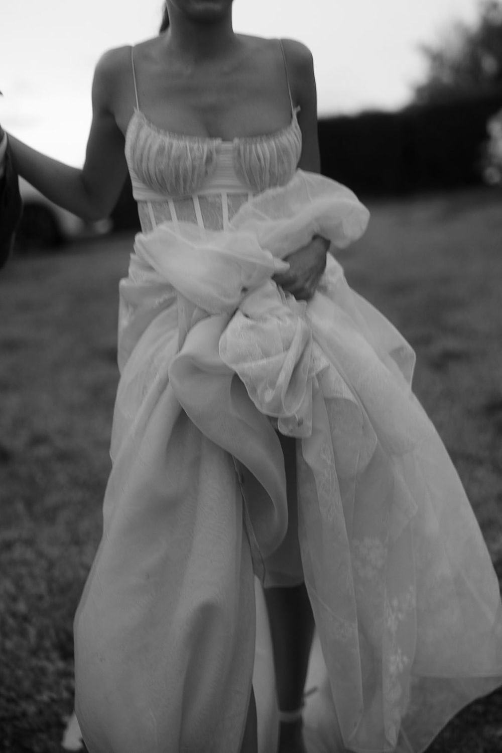 Black and white photo of flowing wedding dress movement captured in artistic detail.