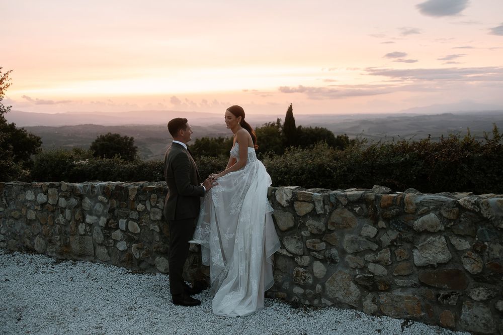 Romantic sunset moment at a stone wall overlooking a Tuscan landscape.