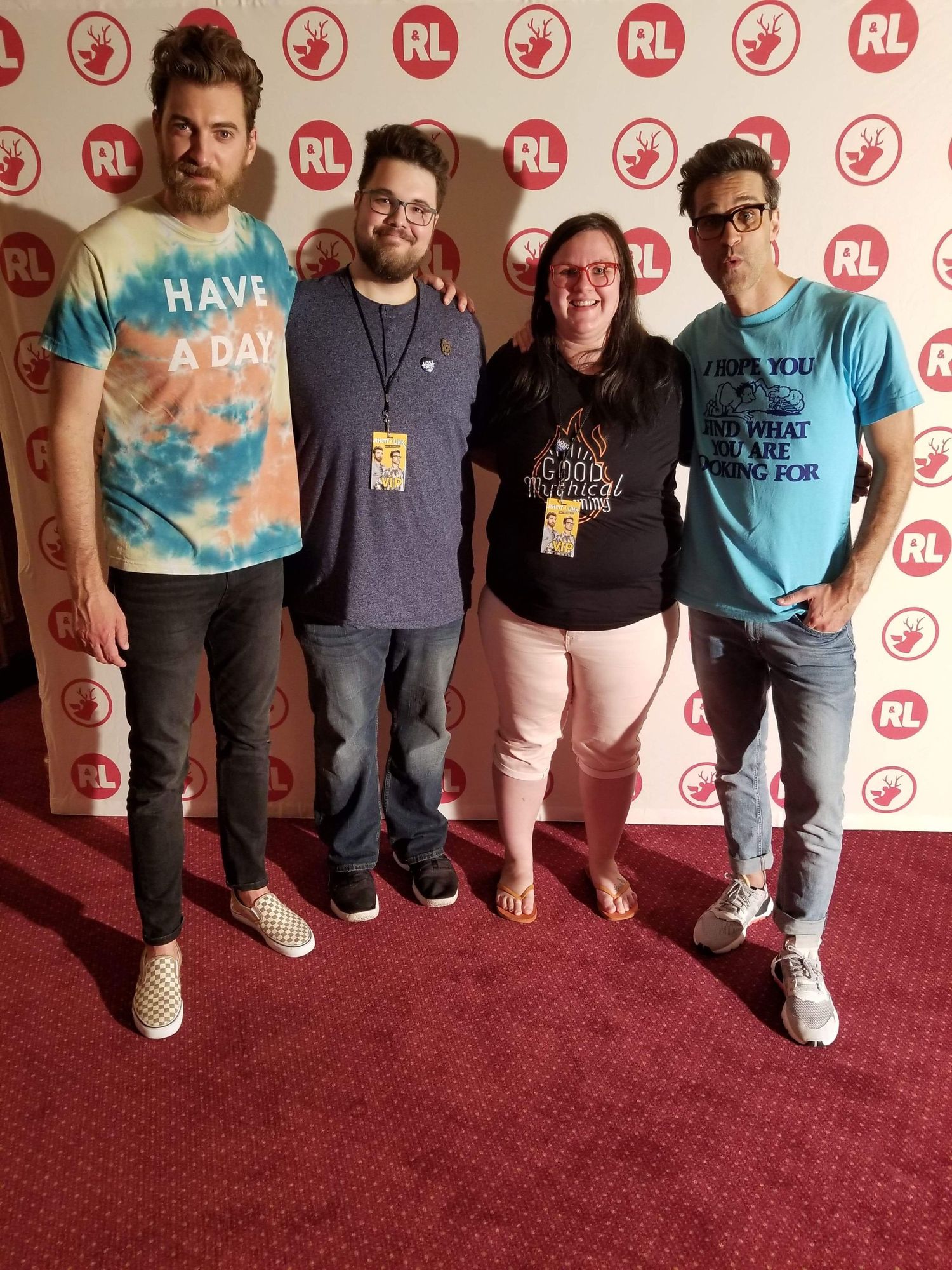Four people pose together on red carpet with RL logos in background wearing casual t-shirts and jeans.