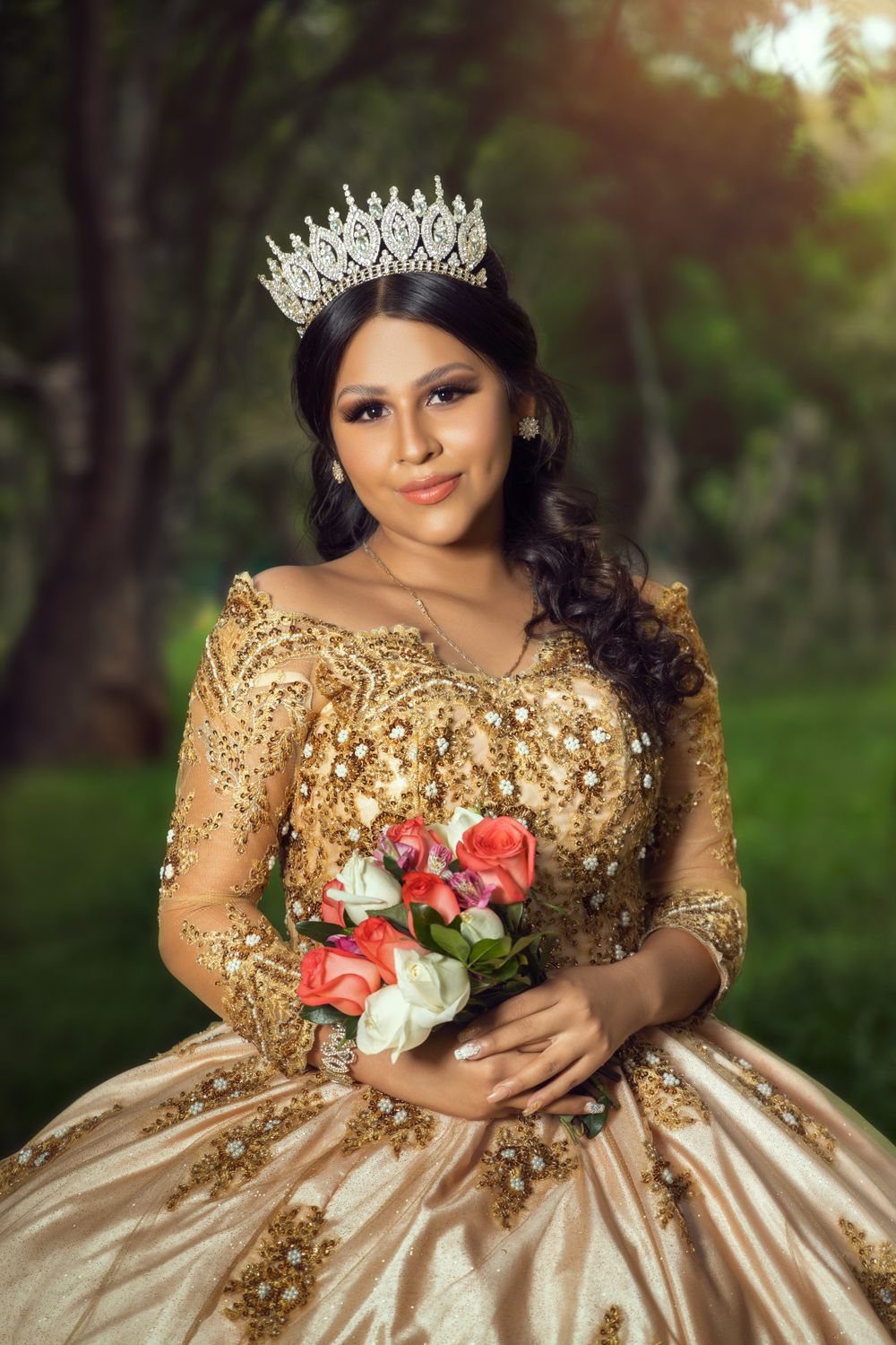 A quinceañera celebration features an ornate gold sequined ball gown, crystal crown, and coral and white roses bouquet.