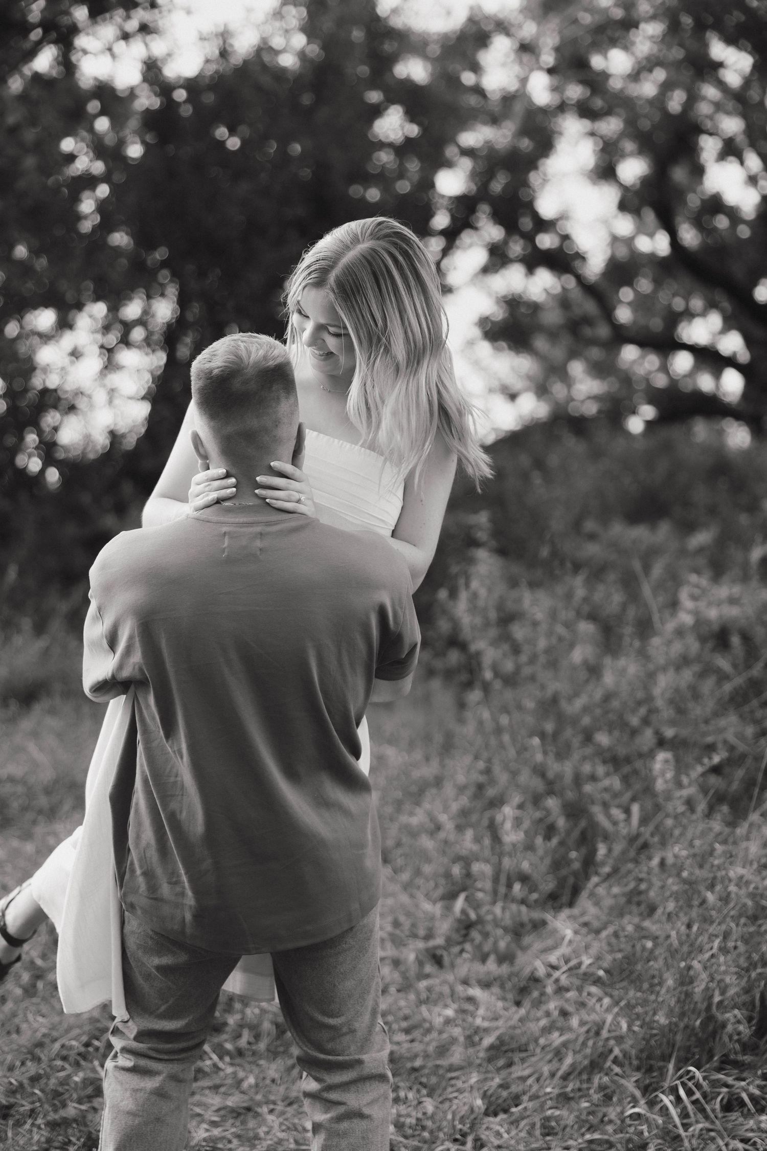 A sweet embrace between two people on a rural hillside.