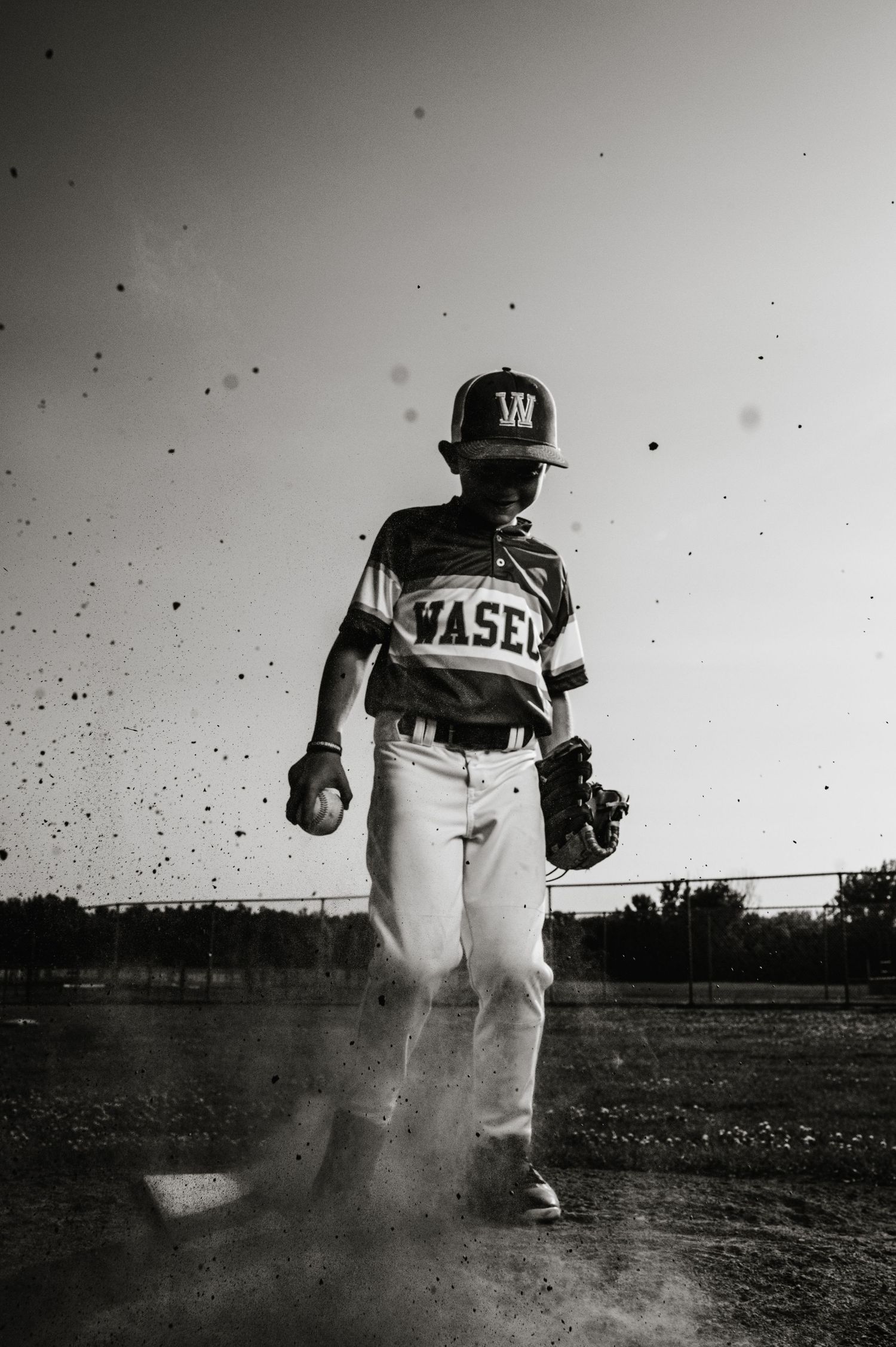 A vintage black and white baseball photo shows an action sequence of a young player throwing a ball in uniform.