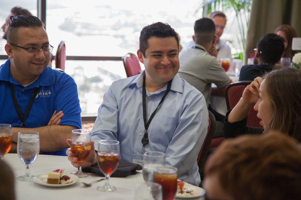 Business professionals seated at tables during a lunch meeting or conference.