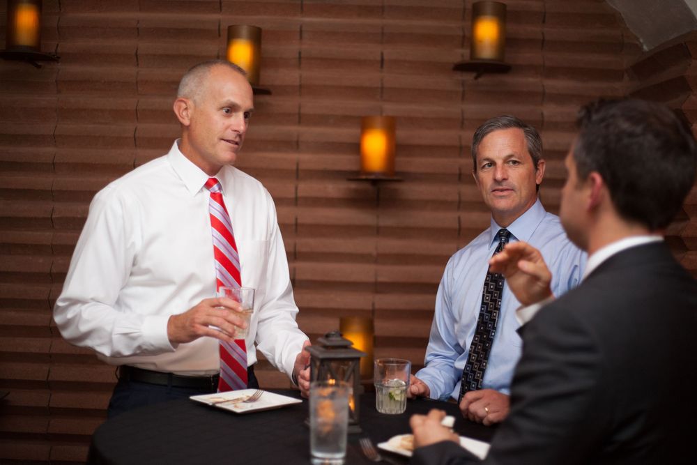 Business colleagues having an informal discussion in a warmly lit room.