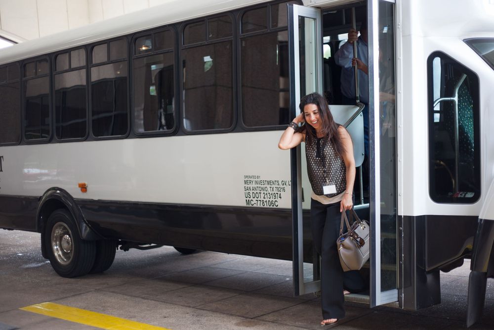 A group of people stand near a service entrance and delivery truck.
