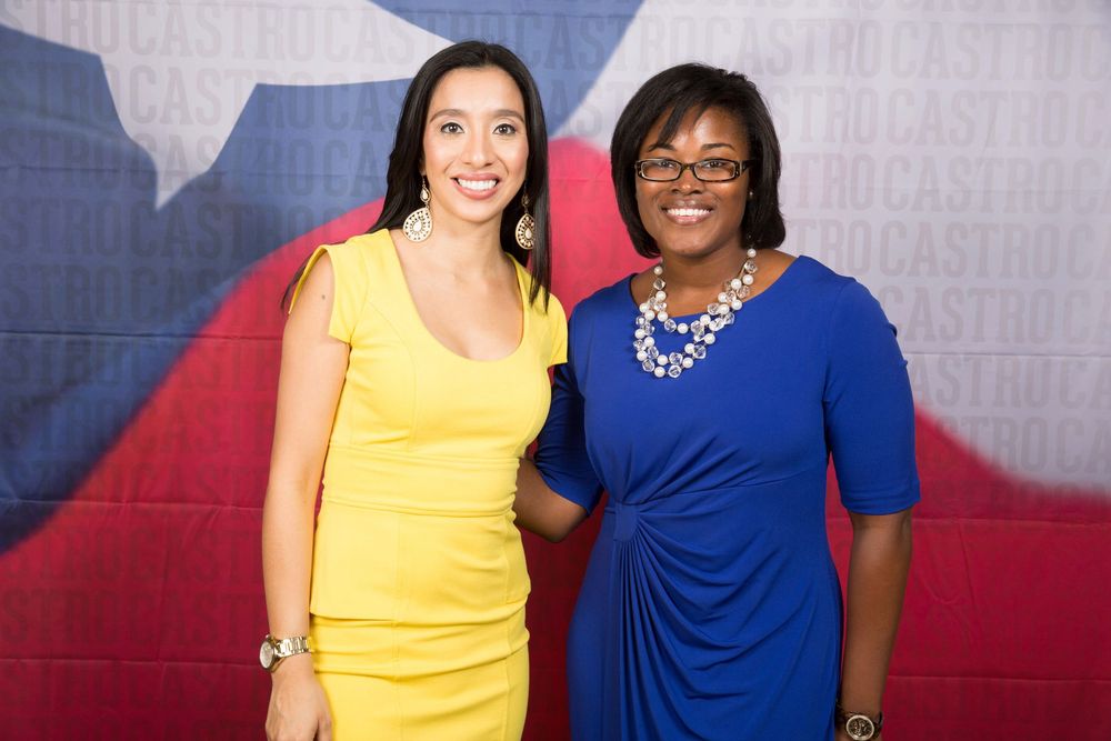 Professional event attendees posing in front of a branded backdrop wall.