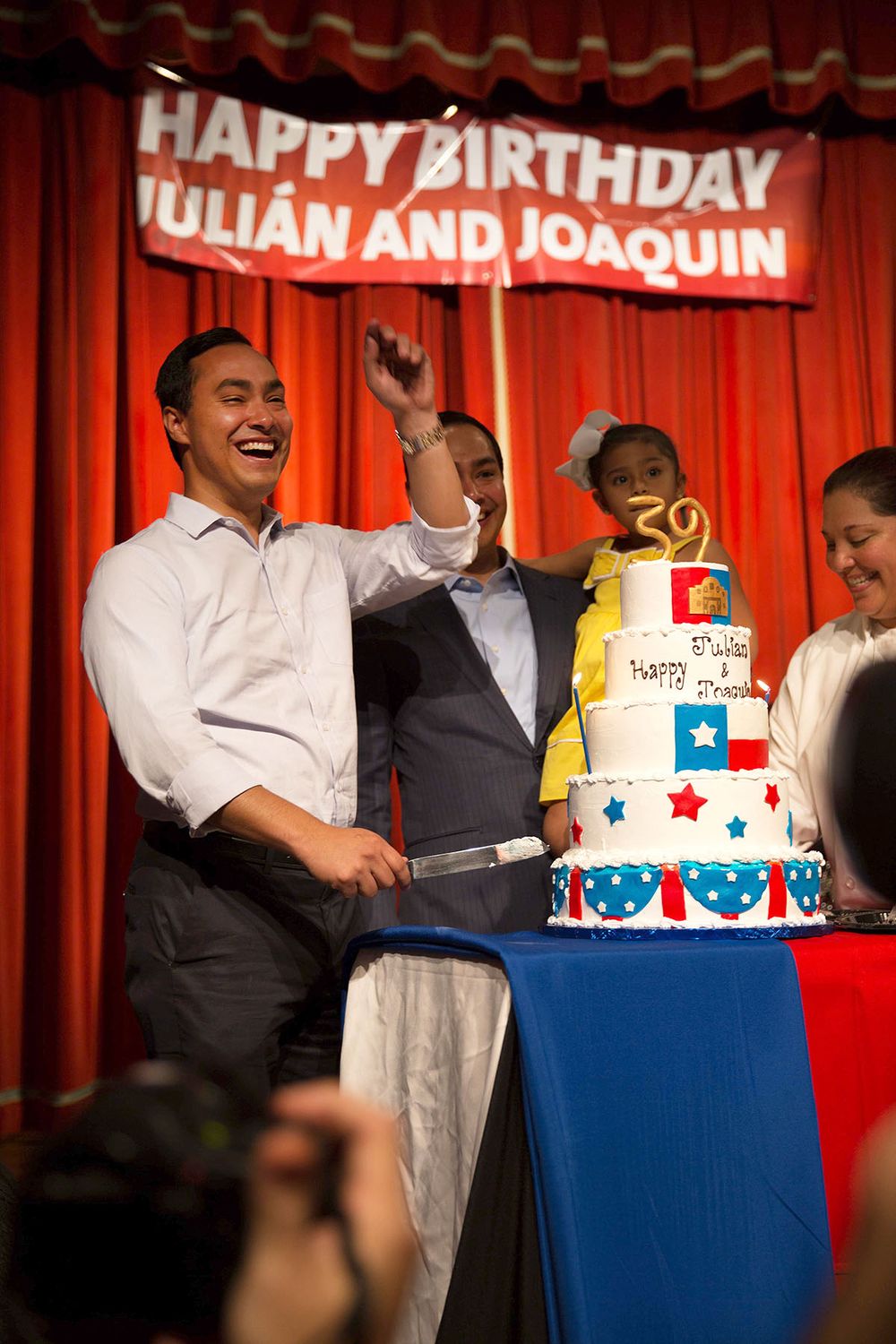 A festive birthday celebration with decorated cake and laughing attendees.
