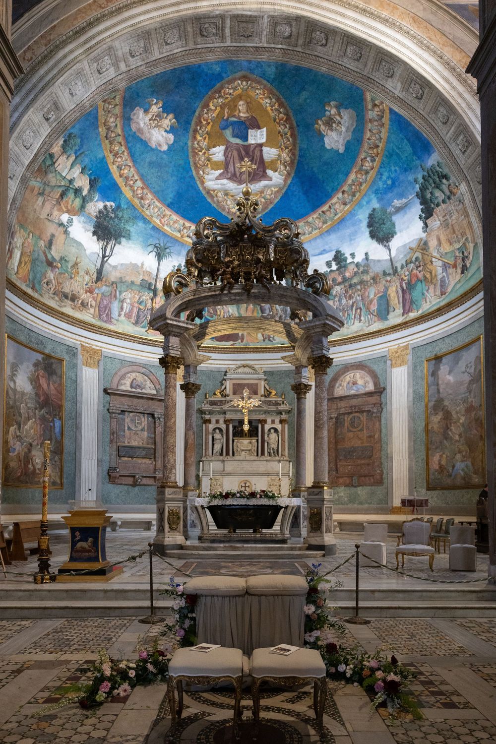 Ornate church interior with blue domed ceiling featuring religious frescoes and classical architectural details.