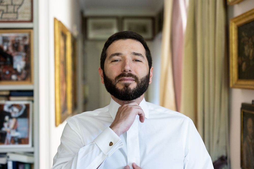 A collection of four similar photos showing someone in a white shirt positioned against an ornate background.