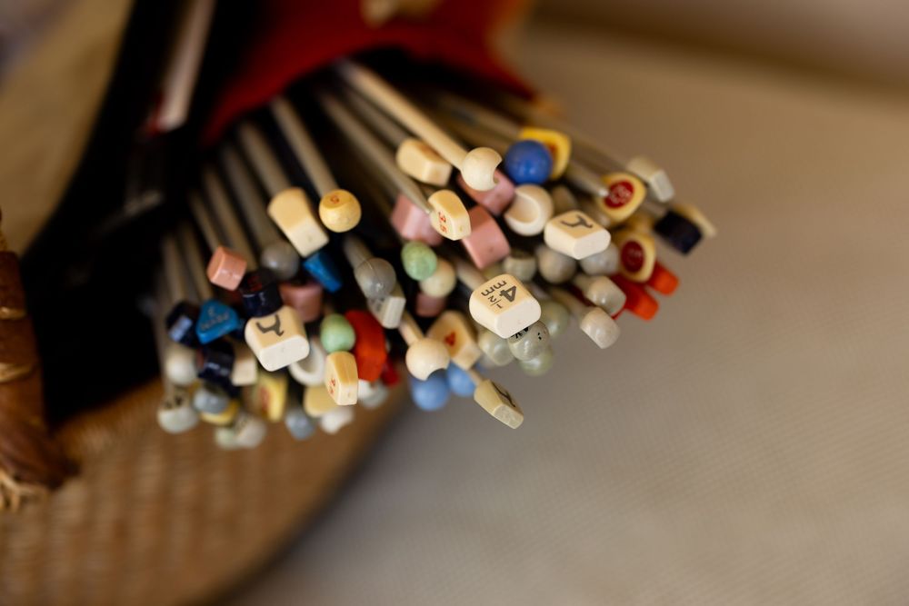 A collection of colorful pens and markers arranged in a row with blurred background lighting effects.
