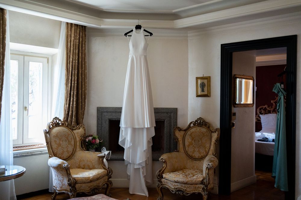 A panoramic view of an elegant room interior with antique chairs and white curtained windows.