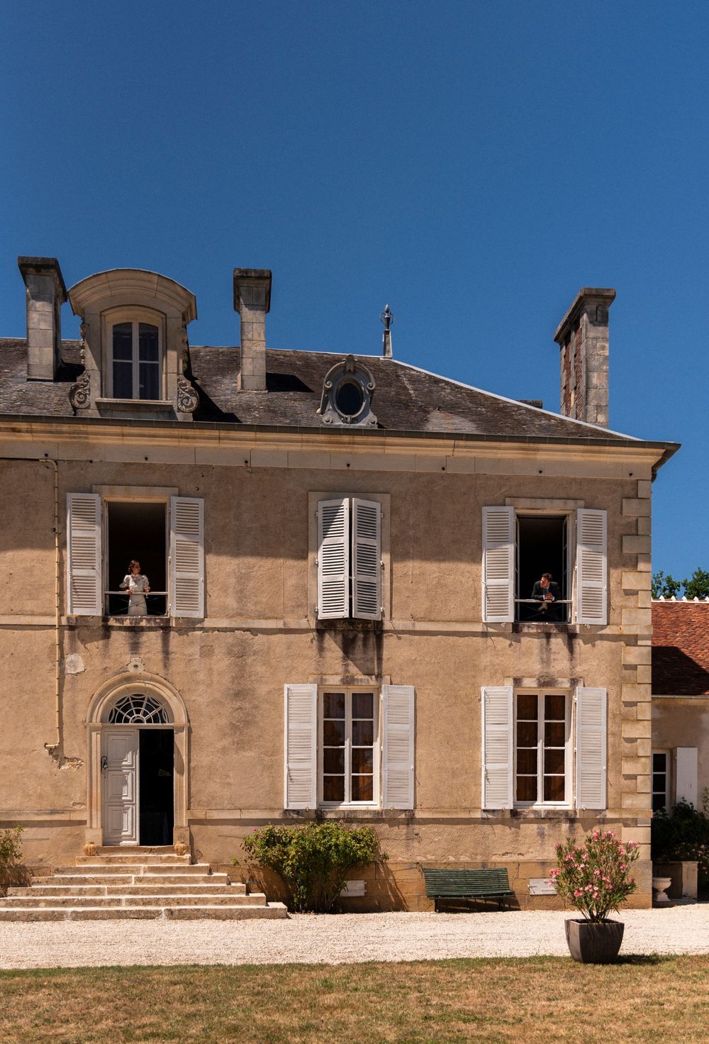 Series of four exterior views showing an old French chateau with classical architecture and windows in warm stone color.