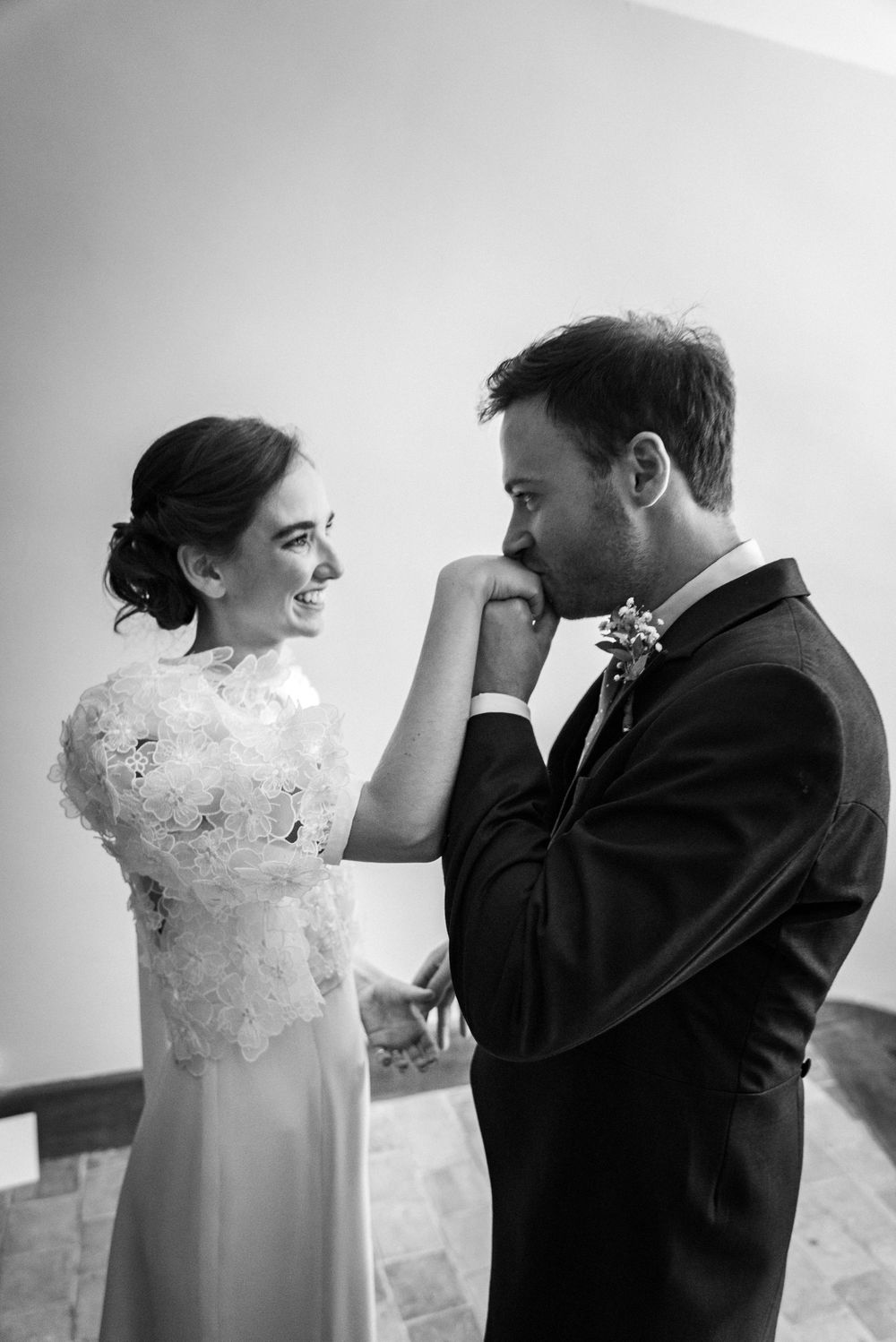 A tender black and white moment capturing a couple creating a playful frame with their hands.