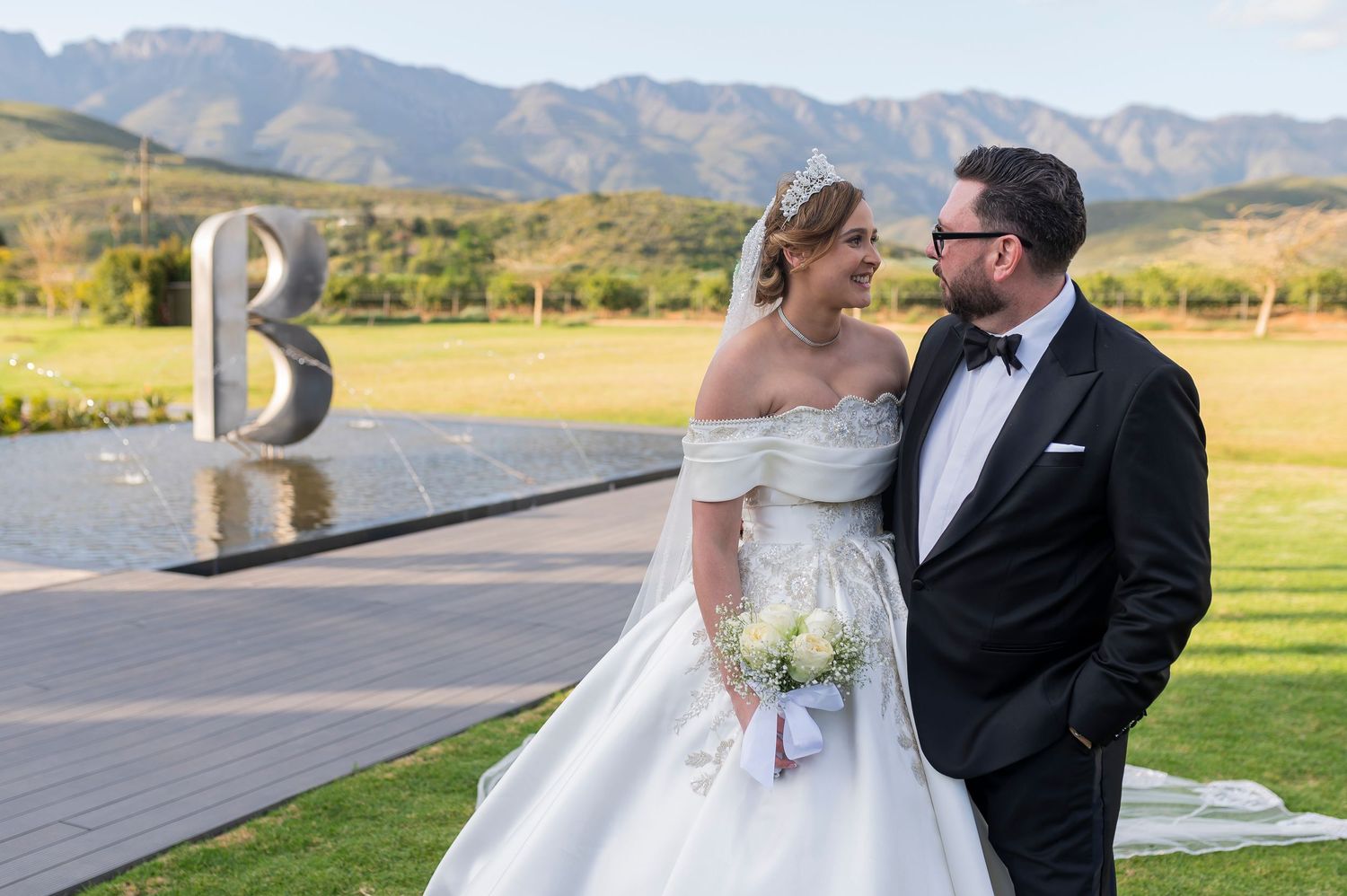 Couple shares romantic moments in scenic mountain landscape during outdoor wedding photo session.
