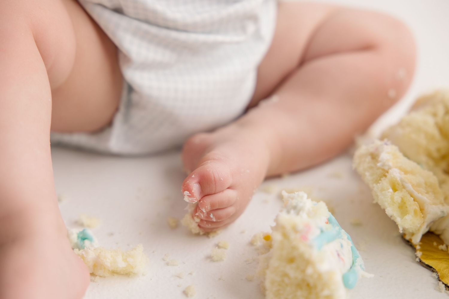 Close up of messy cake crumbs after baby's first birthday cake smash photoshoot.