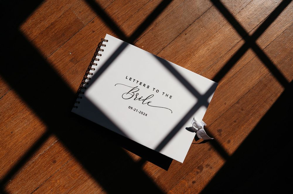 scrapbook gift to bride photographed on wood floors at Sister Hill venue Manchester Iowa by midwest wedding photographer Elisa Tonne