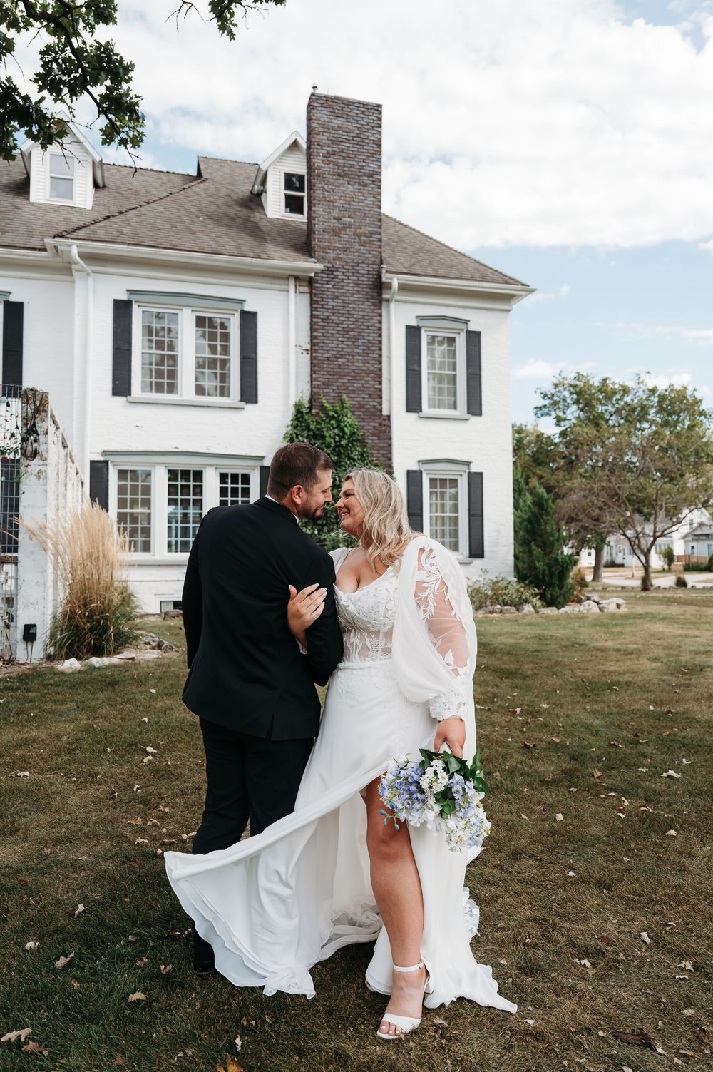 groom & bride embracing outside Sister Hill venue Manchester Iowa by midwest wedding photographer Elisa Tonne of Vibe Photo Co