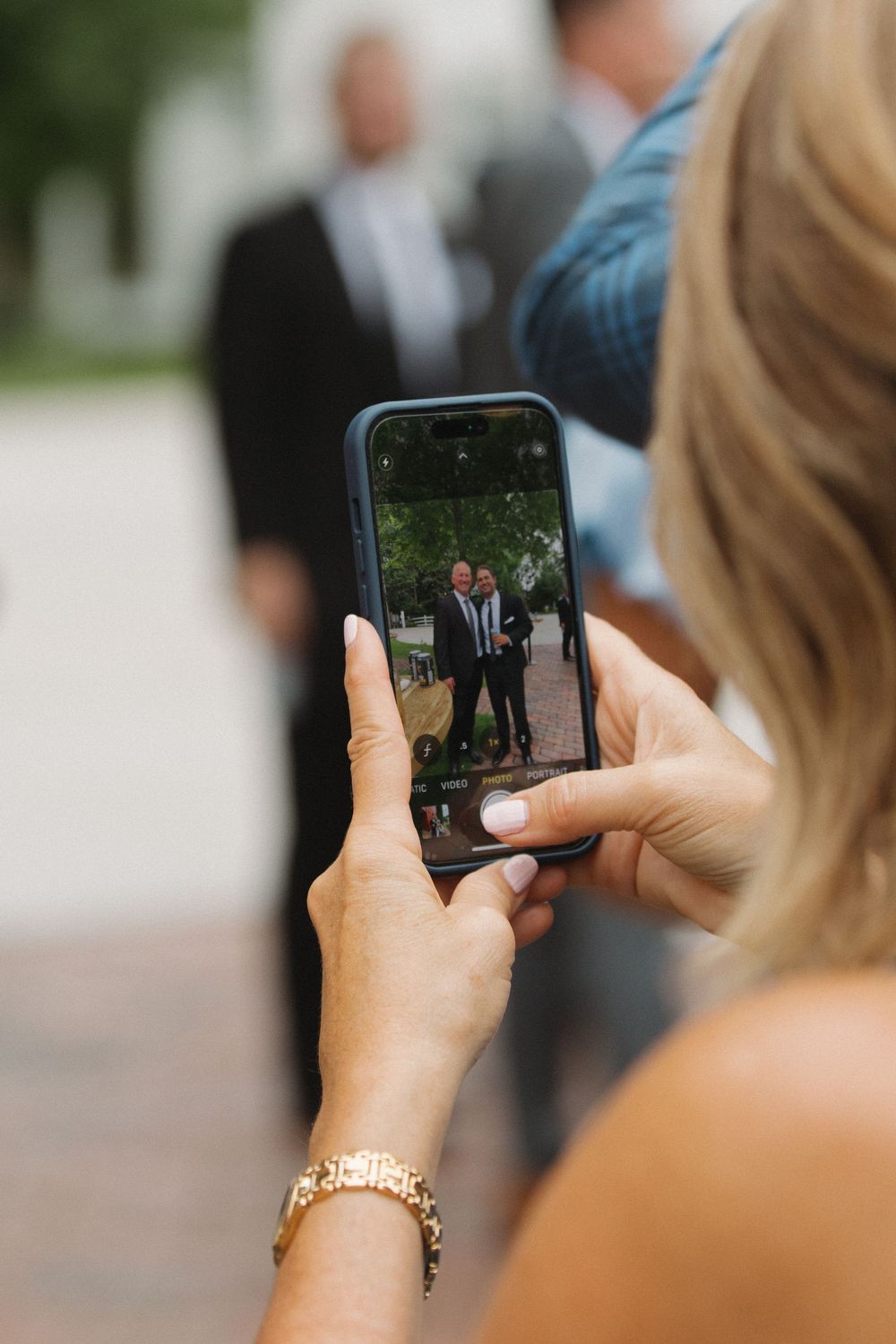 Guest taking photos with smartphone during wedding celebration.