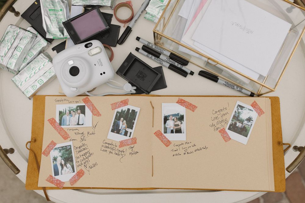 Overhead view of wedding planning materials and photos spread out on a desk.