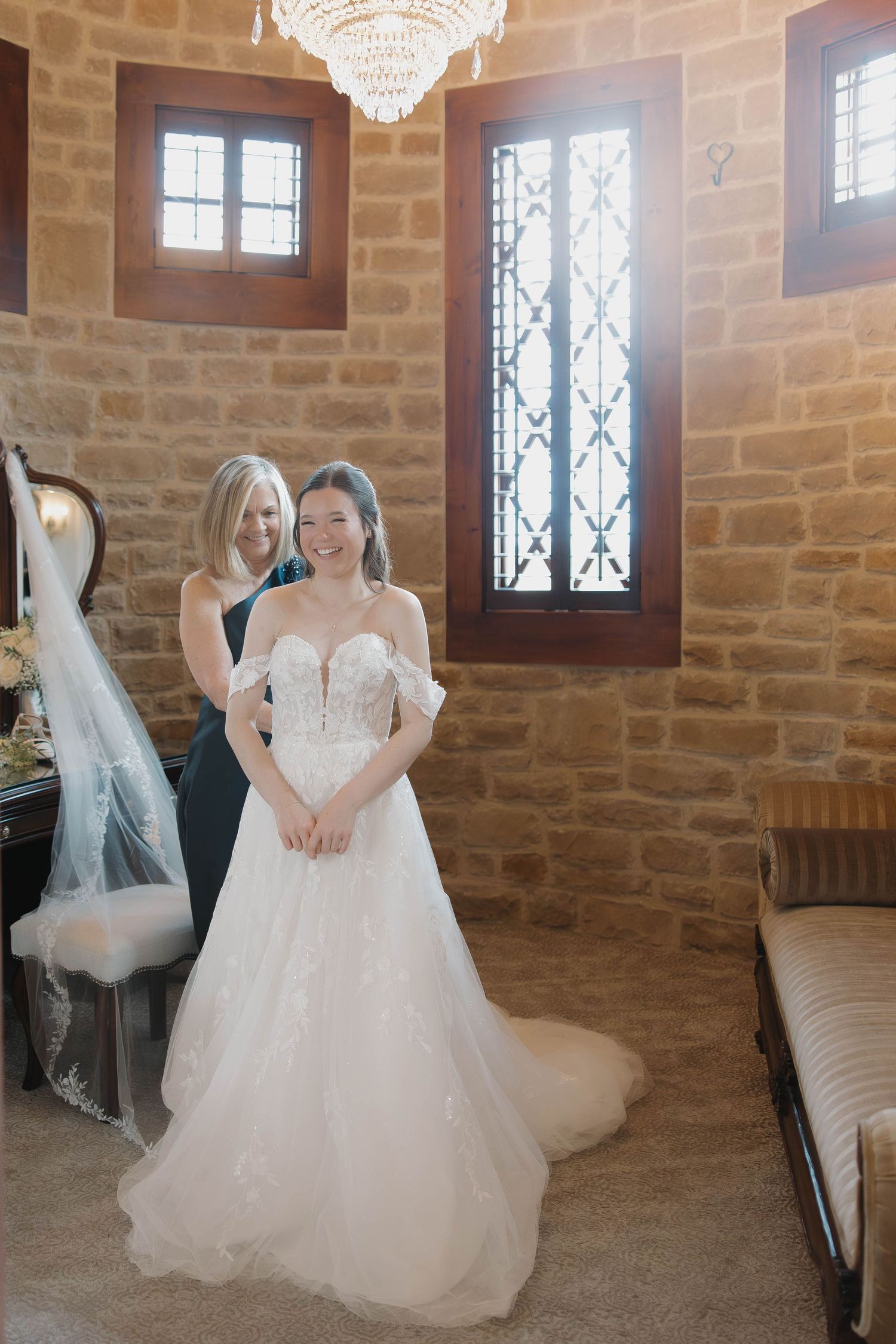A wedding preparation scene shows a beautiful white ballgown dress being fitted in an elegant stone-walled room with chandeliers.