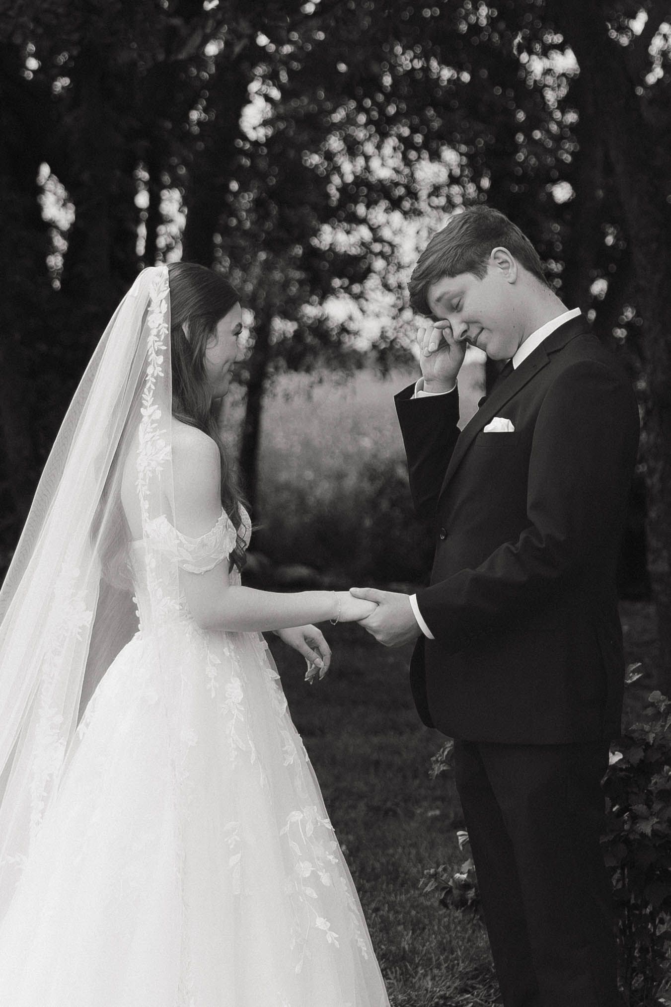 A romantic black and white photo series capturing tender moments between a bride and groom during their outdoor wedding.