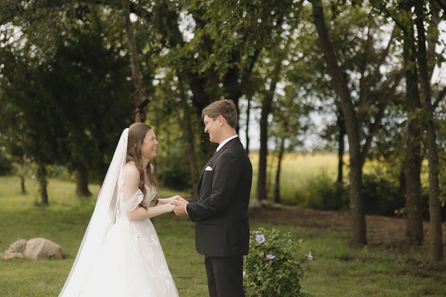 Couple in formal wedding attire shares romantic moments in a lush outdoor garden setting.