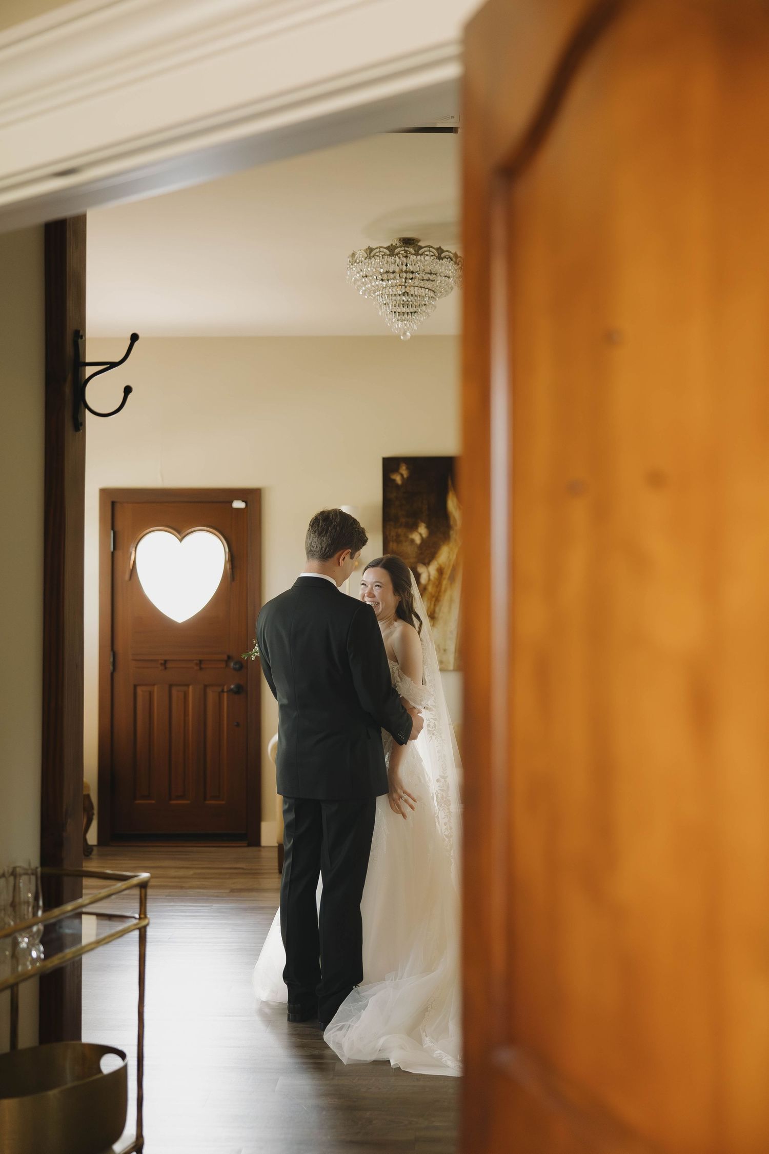 Wedding venue hallway with warm wood paneling and natural light streaming through windows.