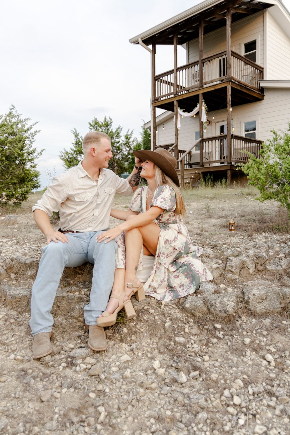 Cowboy hat styled engagement portraits with rustic hill country backdrop in Austin, Texas.