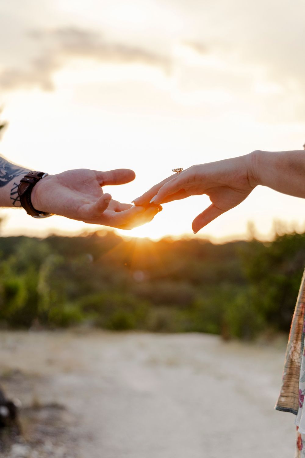 Close-up of hands intertwined with engagement ring in Texas Hill Country proposal session.