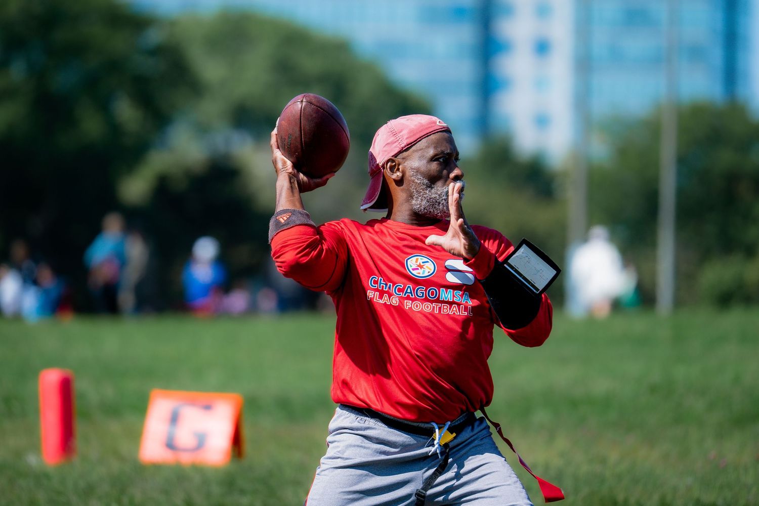 A quarterback winds up to throw a pass in a game of flag football