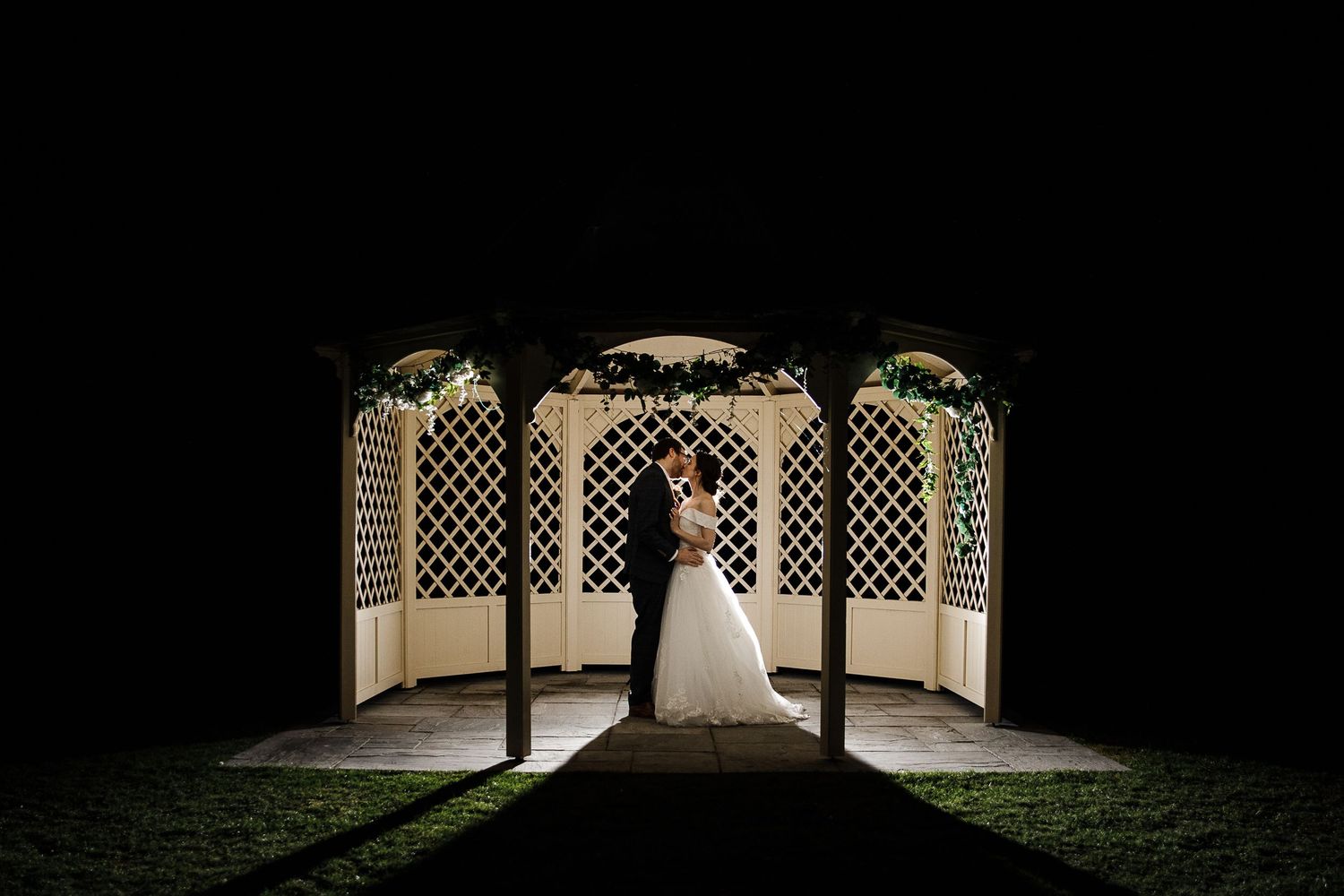 Bride and groom backlit in the Kelham House wedding gazebo at night