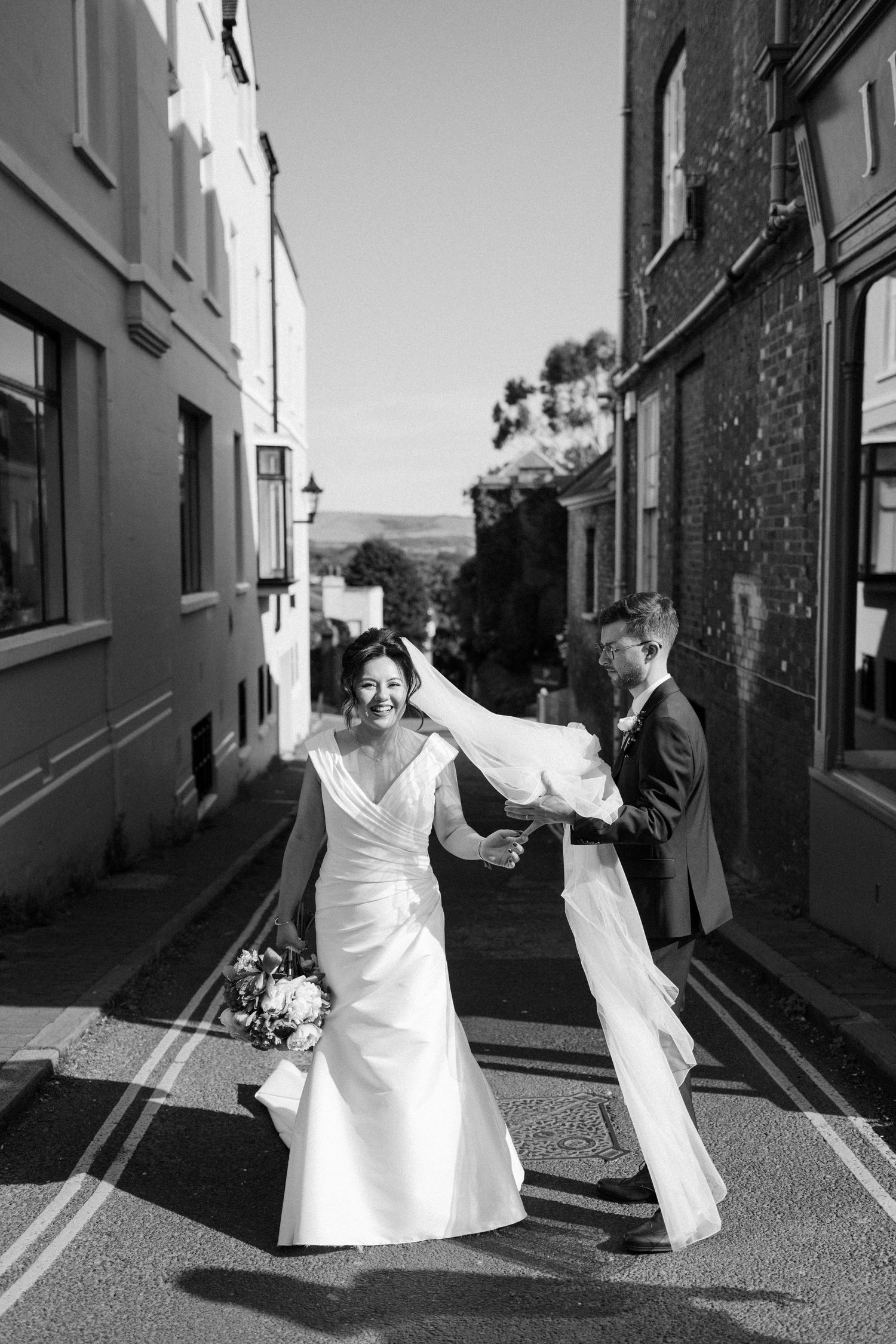 Black and white photo sequence showing couple dancing and twirling in a narrow European alleyway.