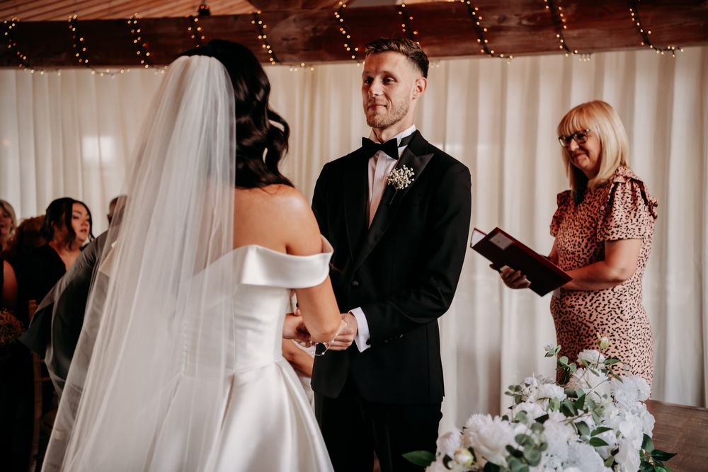 A series of wedding ceremony photos showing tender moments between the couple and guests in an indoor venue.