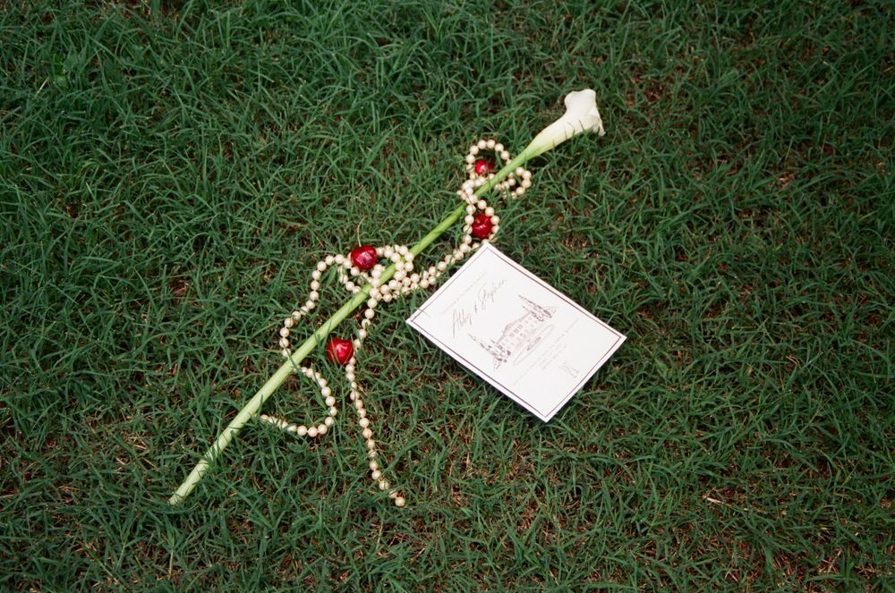 A string of musical note Christmas tree ornaments and decorations arranged on green grass or carpet.
