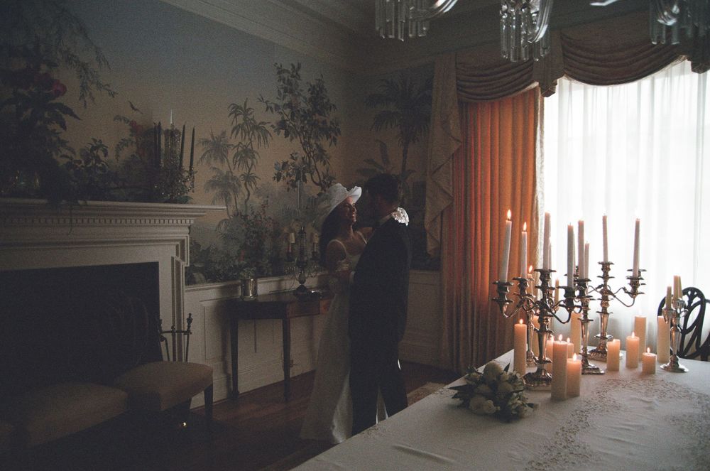 Elegant ballroom with dark silhouettes and candlelit atmosphere creates a dramatic Gothic ambiance during an evening event.