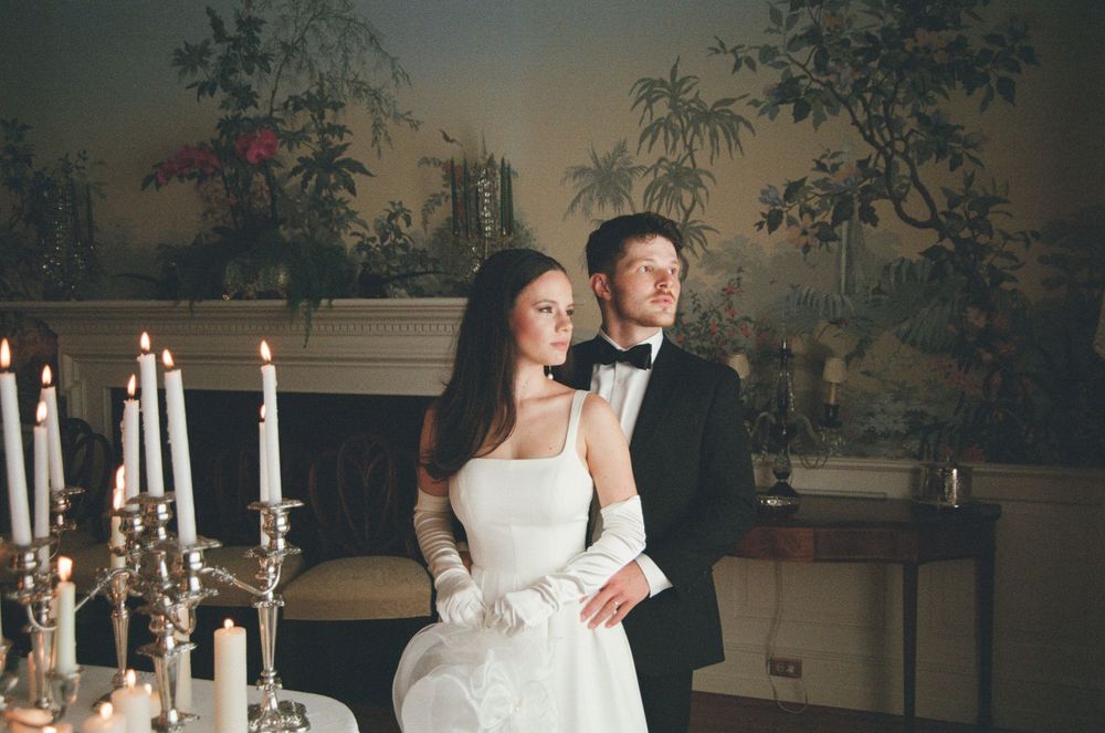Bride in an elegant white wedding gown poses gracefully in front of scenic natural backdrops and candlelit settings.