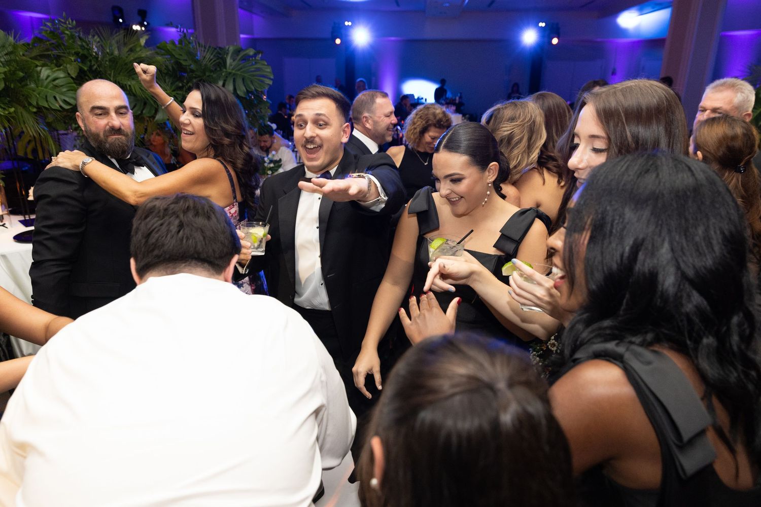 Crowded dance floor scene at a nightclub with blue and purple lighting creating an electric atmosphere.