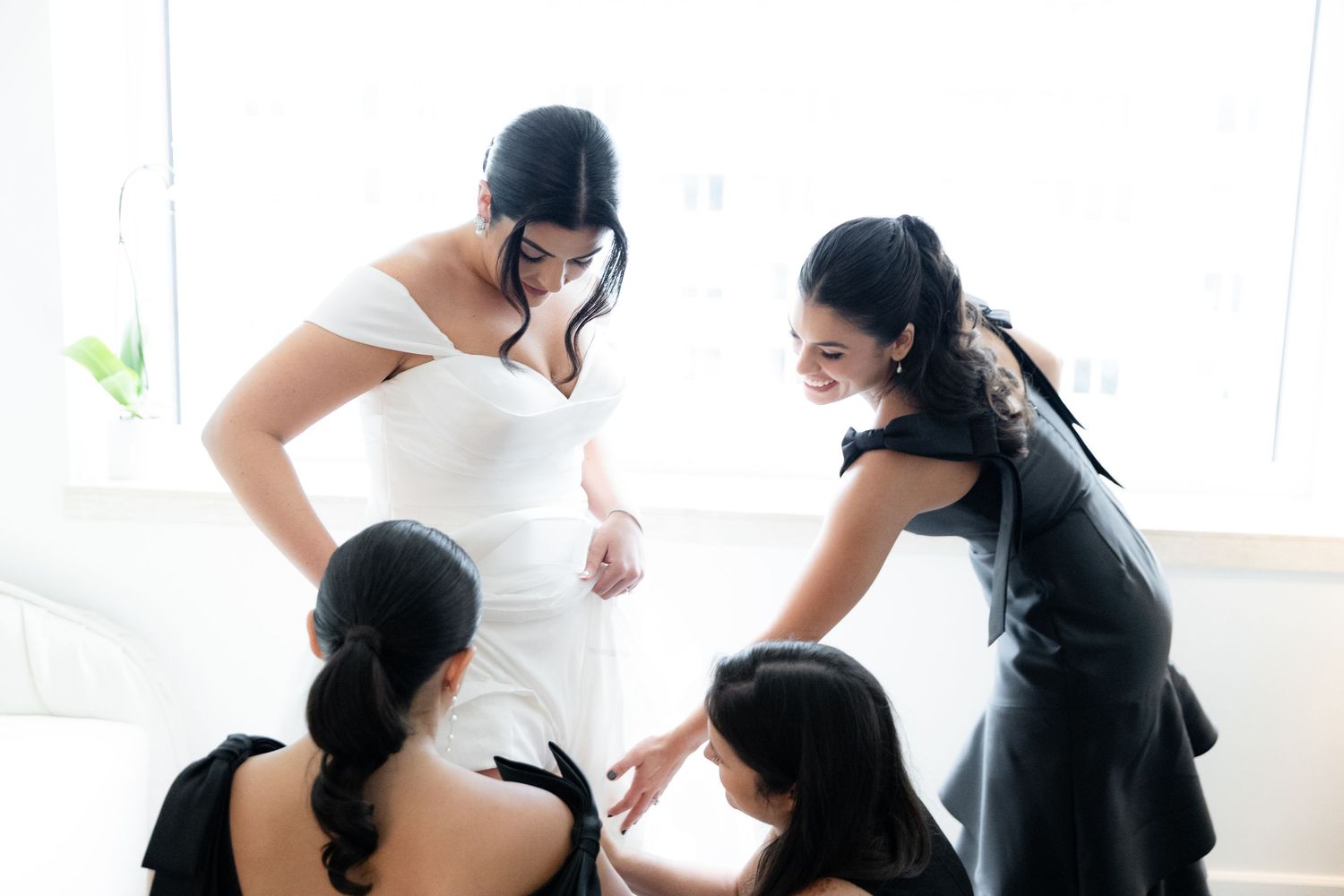 Wedding preparation scene with white dress in natural window light.