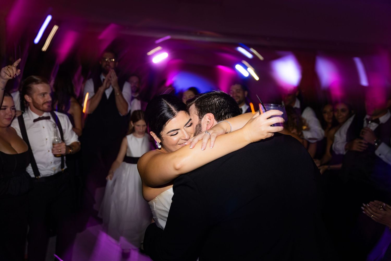Dance party celebration with dramatic purple lighting and silhouettes of people dancing.