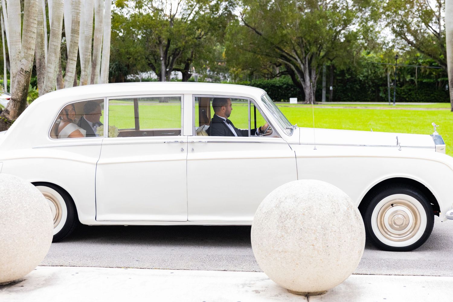 A classic white vintage car parked outside on a sunny day.