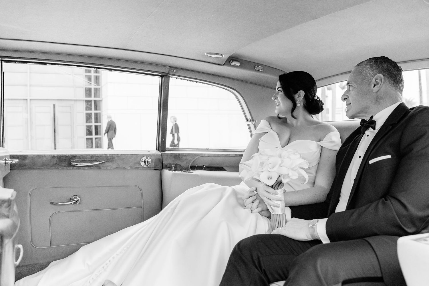 Vintage car interior showing nicely dressed couple seated in formalwear.